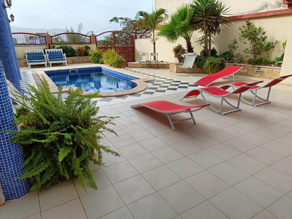a patio with chairs and a swimming pool at Casa Miami in Tarrafal