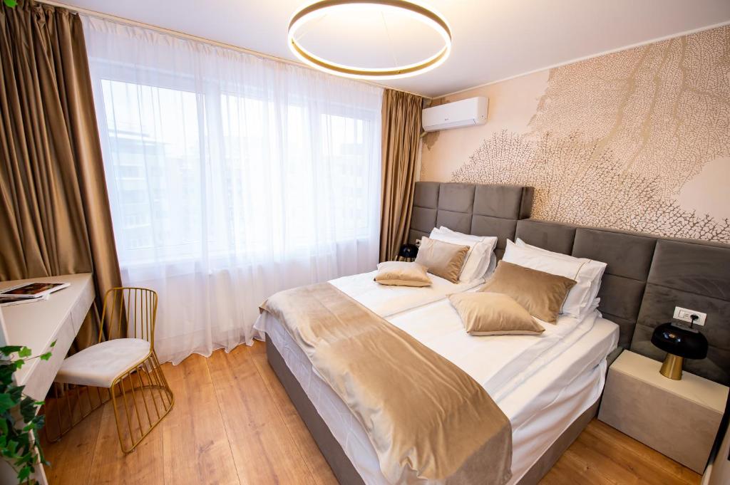 a bedroom with a large bed with a large window at One by One by Grand Accommodation in Bucharest