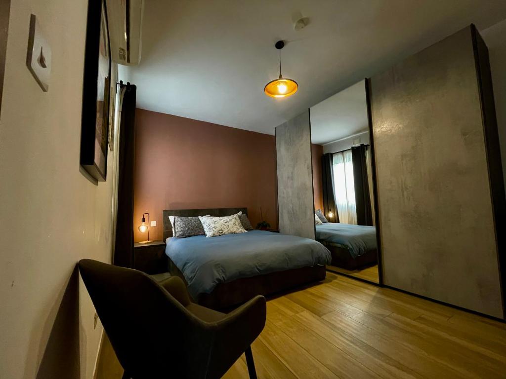 een slaapkamer met een bed, een stoel en een spiegel bij Airport Accommodation Bedroom with your own private Bathroom Self Check In and Self Check Out Air-condition Included in Mqabba