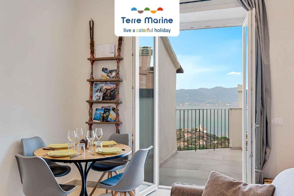 ein Esszimmer mit einem Tisch und Stühlen sowie einem Balkon in der Unterkunft La Frida, Terre Marine in Lerici