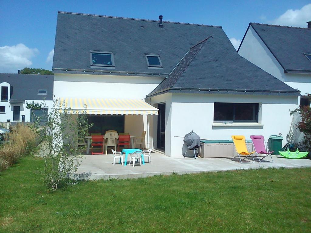 Cette maison blanche dispose de chaises colorées et d'une terrasse. dans l'établissement Maison au calme proche des plages du Golfe du Morbihan, à Baden