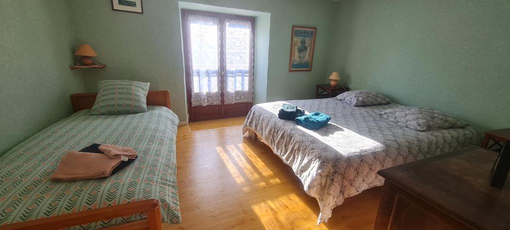 a bedroom with two beds and a window at gîte la tanière de claire in Ségur