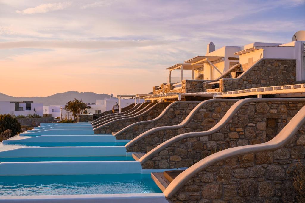 a row of stairs leading down to a resort pool at Ovea Mykonos in Mikonos