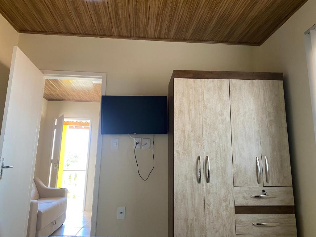 a room with a wooden ceiling and a cabinet at Flat Beira Mar no Condomínio Diver in Vera Cruz de Itaparica