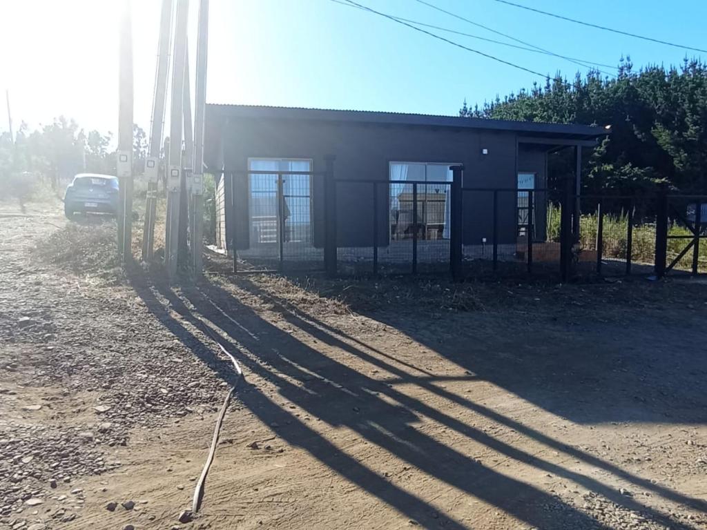 un edificio con un coche aparcado delante de él en Cabaña Curanipe Playa, en Curanipe