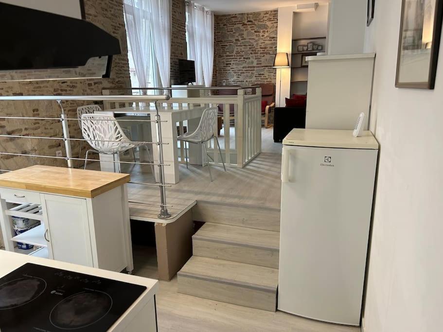a kitchen with a refrigerator and a table and chairs at Coeur de Bastide in Villeneuve-sur-Lot