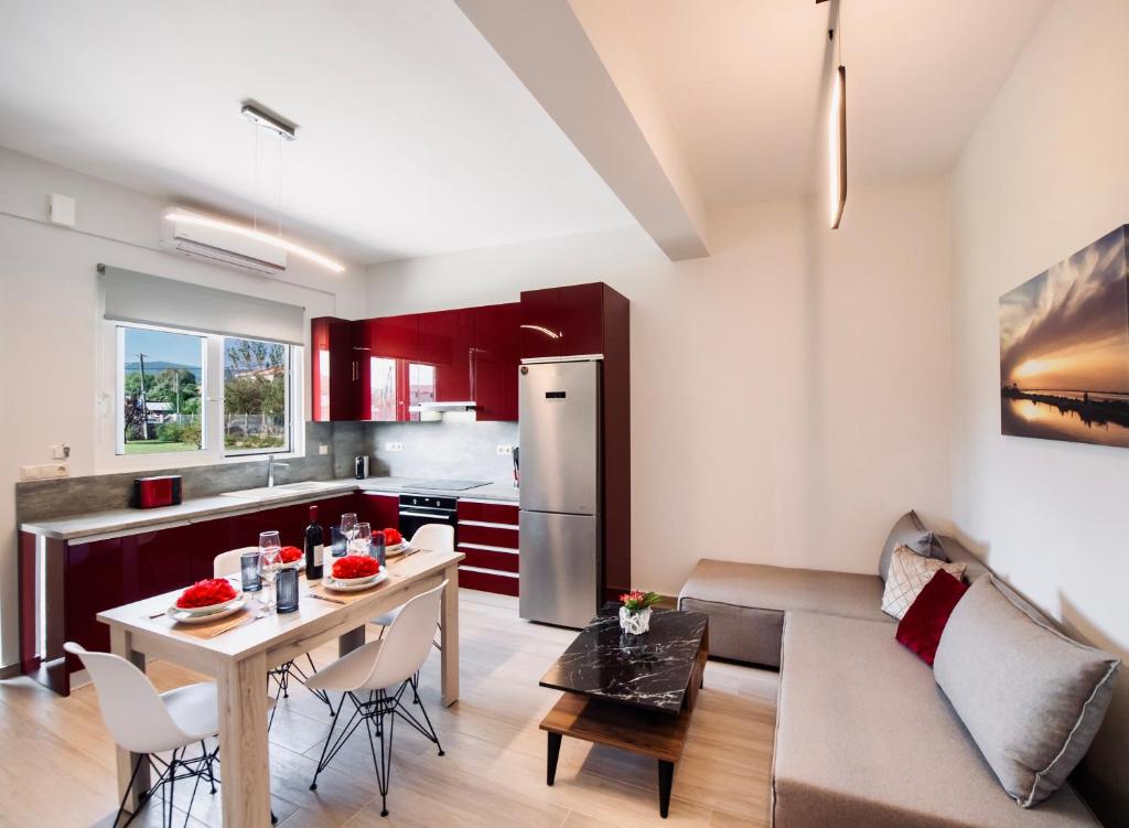 uma cozinha e sala de estar com uma mesa e um sofá em Ruellia Luxury Apartments em Lefkada