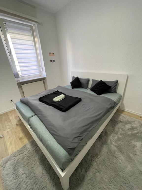 un letto in una camera da letto con un accappatoio nero. di Zentrale gemütliche Wohnung a Saarbrücken