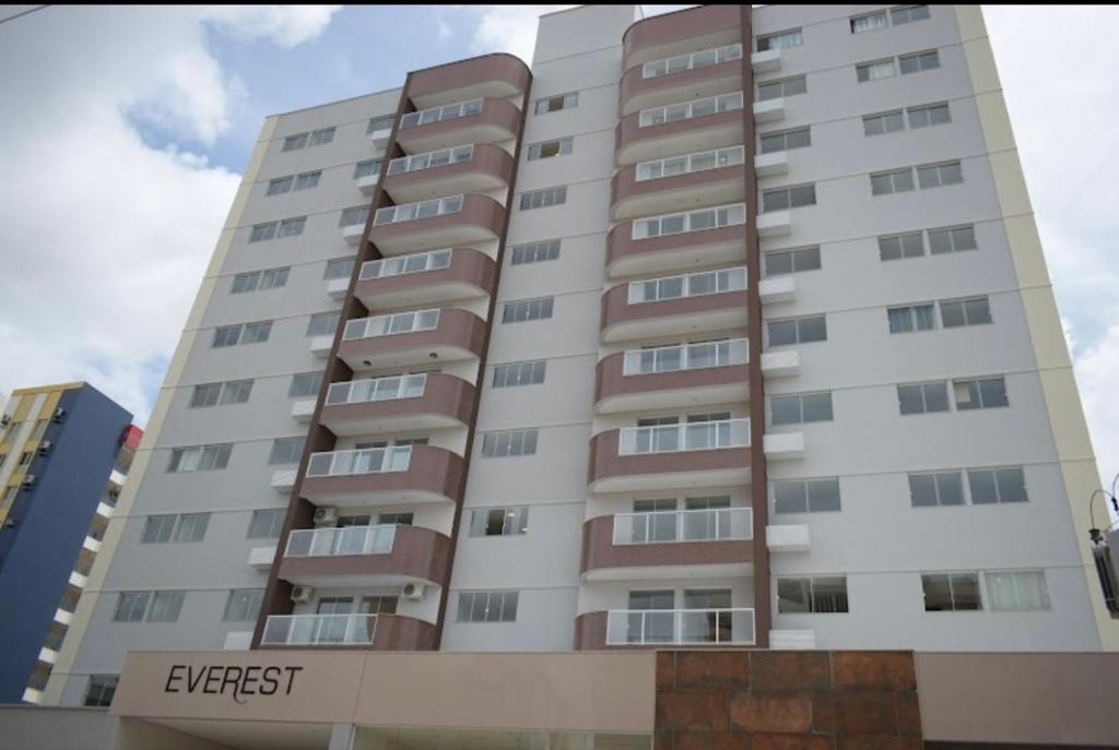 un edificio de apartamentos alto y blanco con las palabras salida en Condomínio Everest Flat, en Caldas Novas