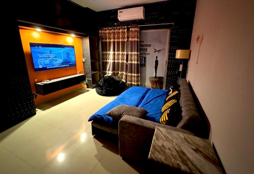 a living room with a couch and a flat screen tv at zooFamily in Dhaka