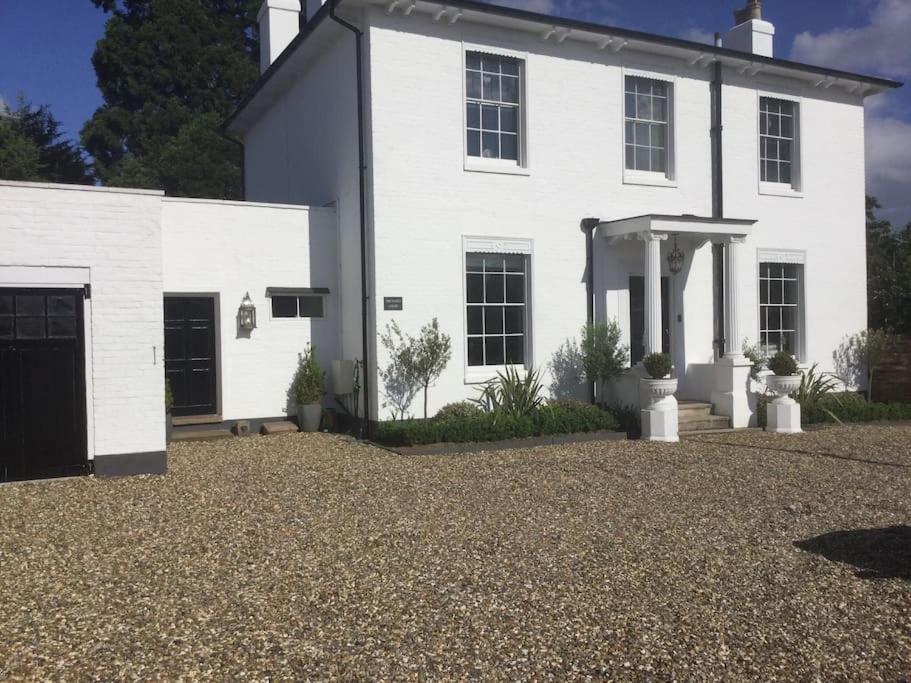 a white house with a gravel driveway at Lovely Annexe near Surbiton/Kingston, SW London in Chessington