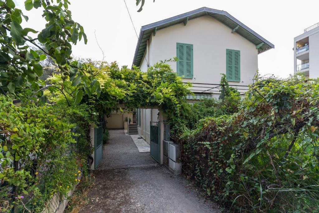 une petite maison blanche avec une allée couverte de lierre dans l'établissement appartement RDC, à Antibes