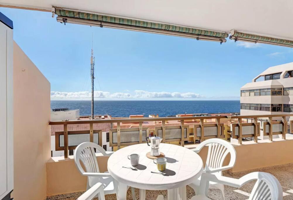 una mesa y sillas en el balcón de un crucero en Costa Azul apartamento con vista, en Candelaria