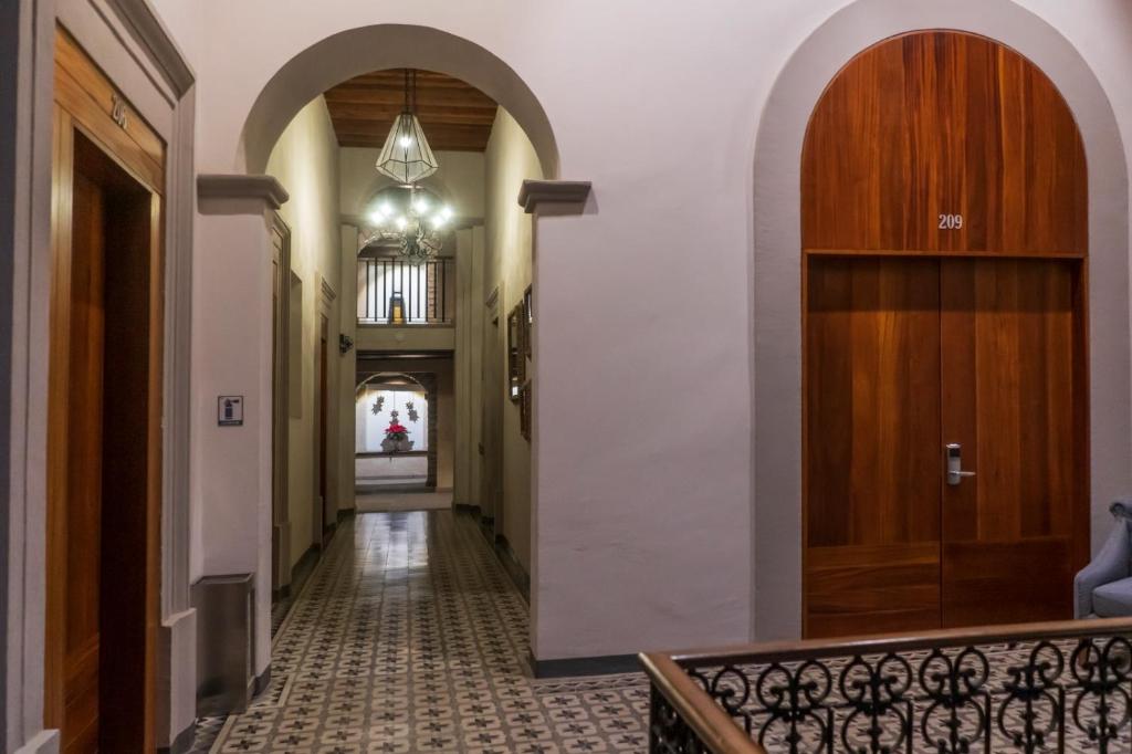 un couloir avec des arches et un couloir avec une porte dans l'établissement Hotel Madero, à Querétaro
