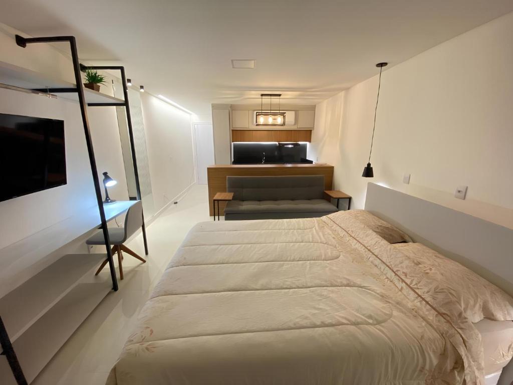 1 dormitorio con cama, sofá y mesa en Flat Home Business 202 Centro Pomerode en Pomerode