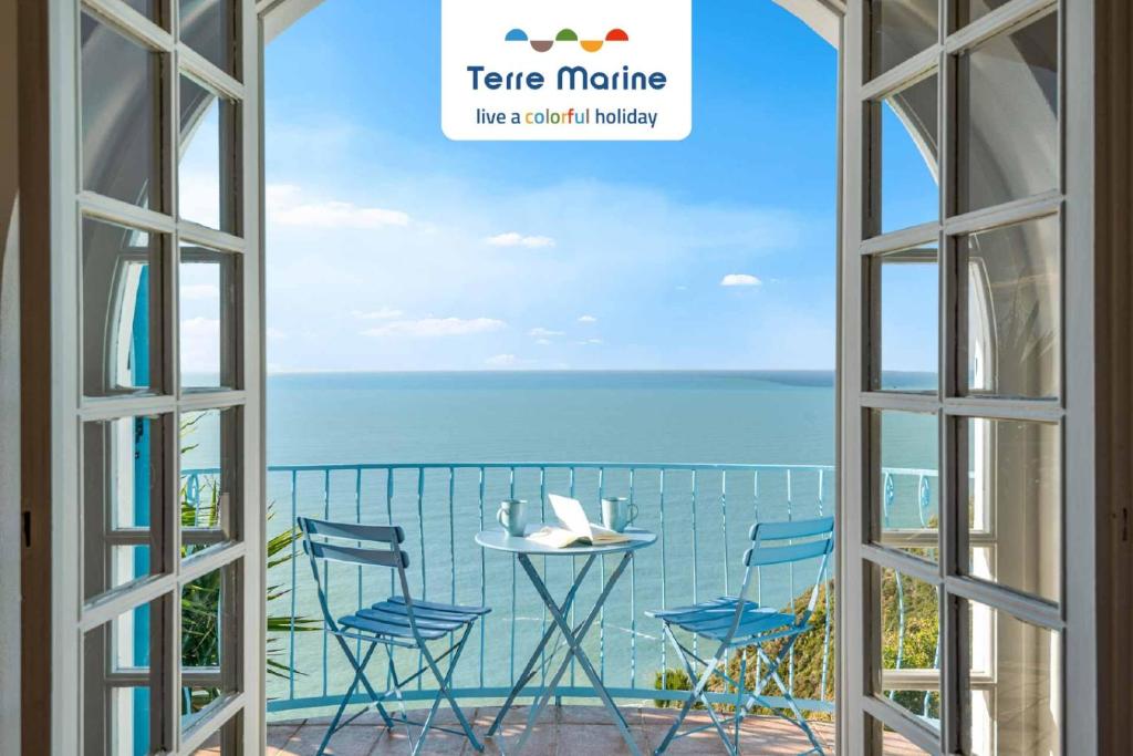 una ventana abierta con una mesa y sillas con vistas al océano en La Tana della Faina, TerreMarine, en Biassa