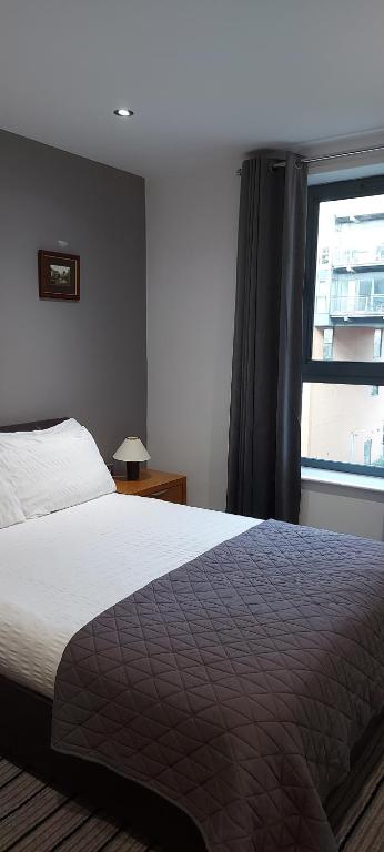 a bedroom with a large bed and a window at City Location with a Balcony & Parking - West One in Sheffield