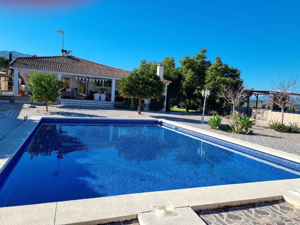 a swimming pool in front of a house at Finca Vista El Montanes in Málaga