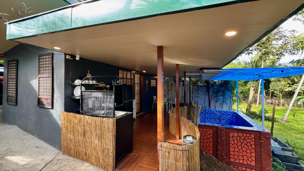 an outdoor bar with a blue umbrella on a house at The Orchard Private Villa with Pool and Wifi in Cuenca Batangas in Cuenca