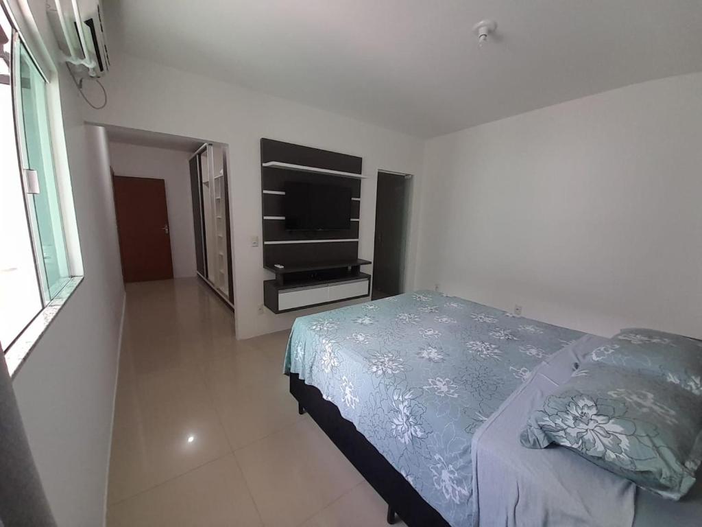um quarto com uma cama e uma televisão de ecrã plano em Casa a 200 mts da praia - prox Aeroporto NVG - CASA DA MEIA PRAIA em Navegantes