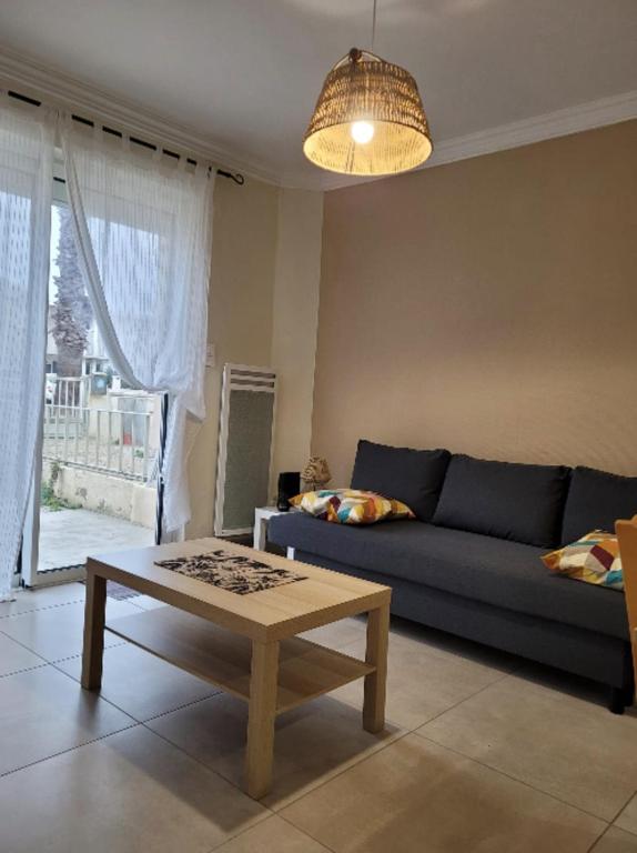 un salon avec un canapé bleu et une table basse dans l'établissement Apartment with garden - sea view, à Palavas-les-Flots
