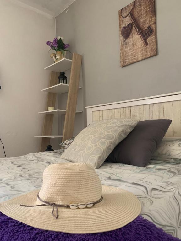 a straw hat sitting on top of a bed at Apartamento maspalomas 3 hab stay in gran canaria in Maspalomas