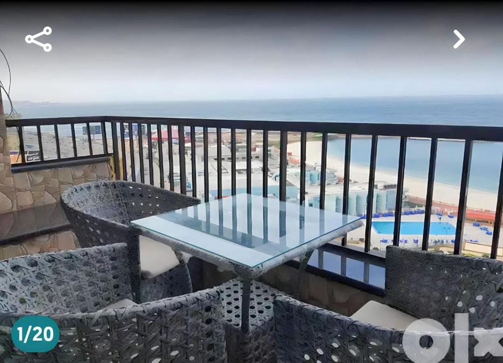 a table on a balcony with a view of the beach at City Square in Alexandria