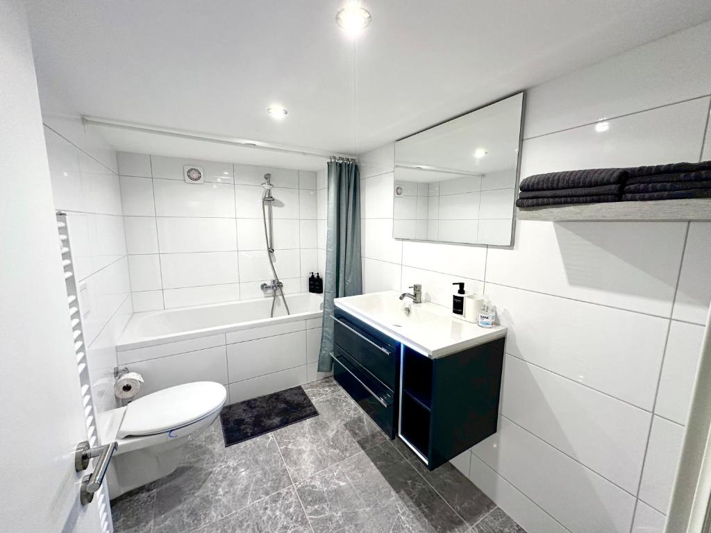 Un baño con lavabo, bañera e inodoro. en Micro Apartment Leipzig, en Leipzig