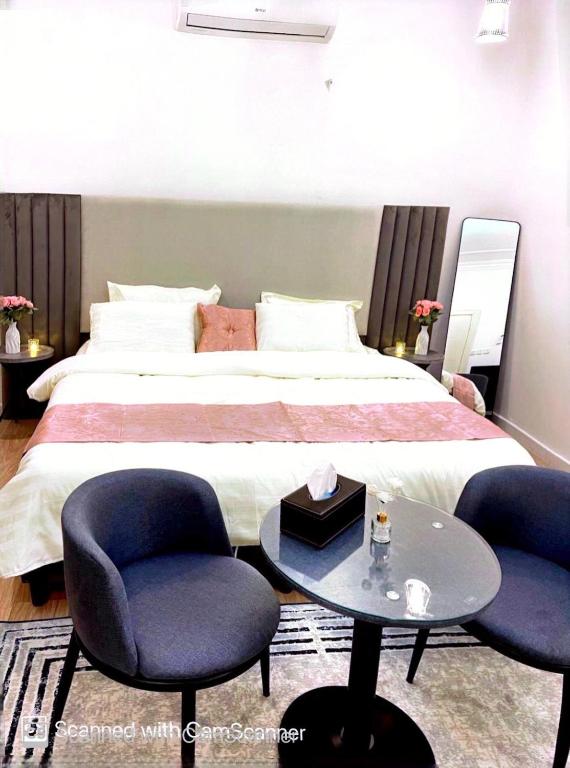 sypialnia z łóżkiem z 2 krzesłami i stołem w obiekcie استديو بأثاث انيق -النقرة w mieście Ha'il