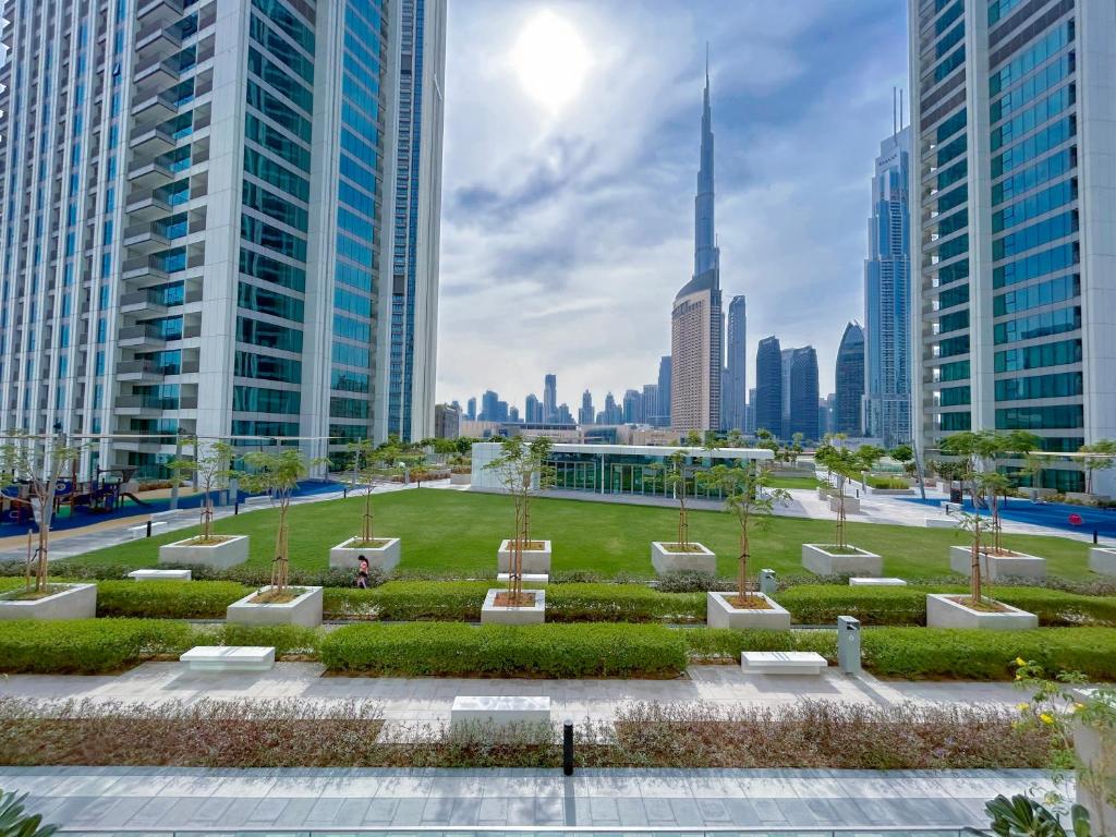 a park in the middle of a city with tall buildings at Stunning 2Bedroom with balcony Dubai Mall access in Dubai