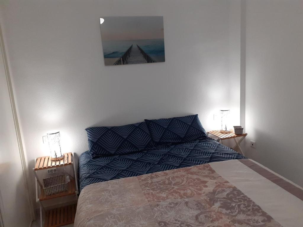 1 dormitorio con 1 cama y una foto en la pared en Appartement avec vue sur baie de Malaga, en Torre de Benagalbón