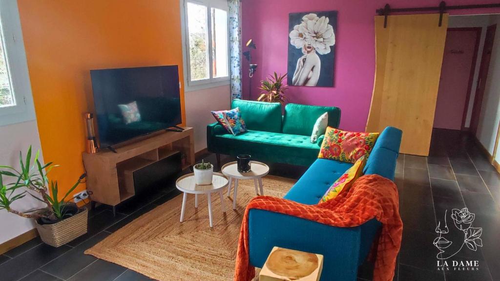 een woonkamer met een bank en een tv bij La dame aux fleurs in Lavaur