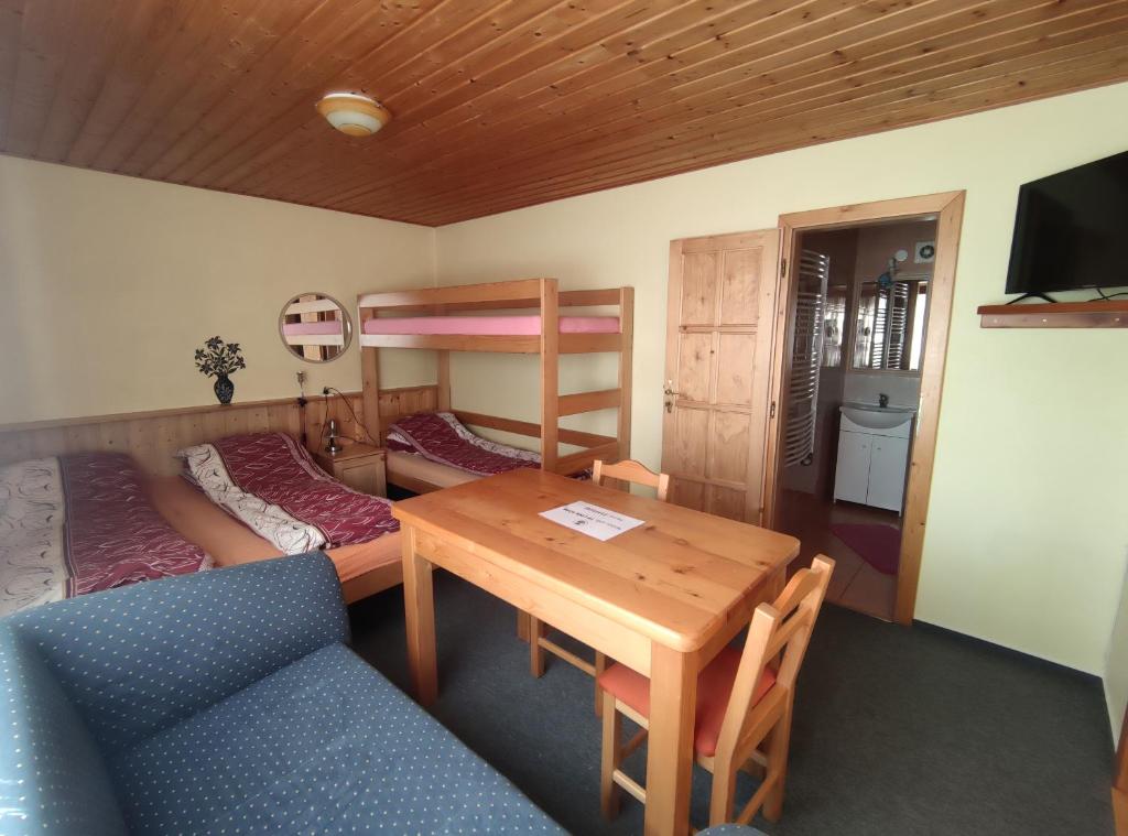 um quarto com uma mesa, uma cama e beliches em privat kobr em Rokytnice nad Jizerou