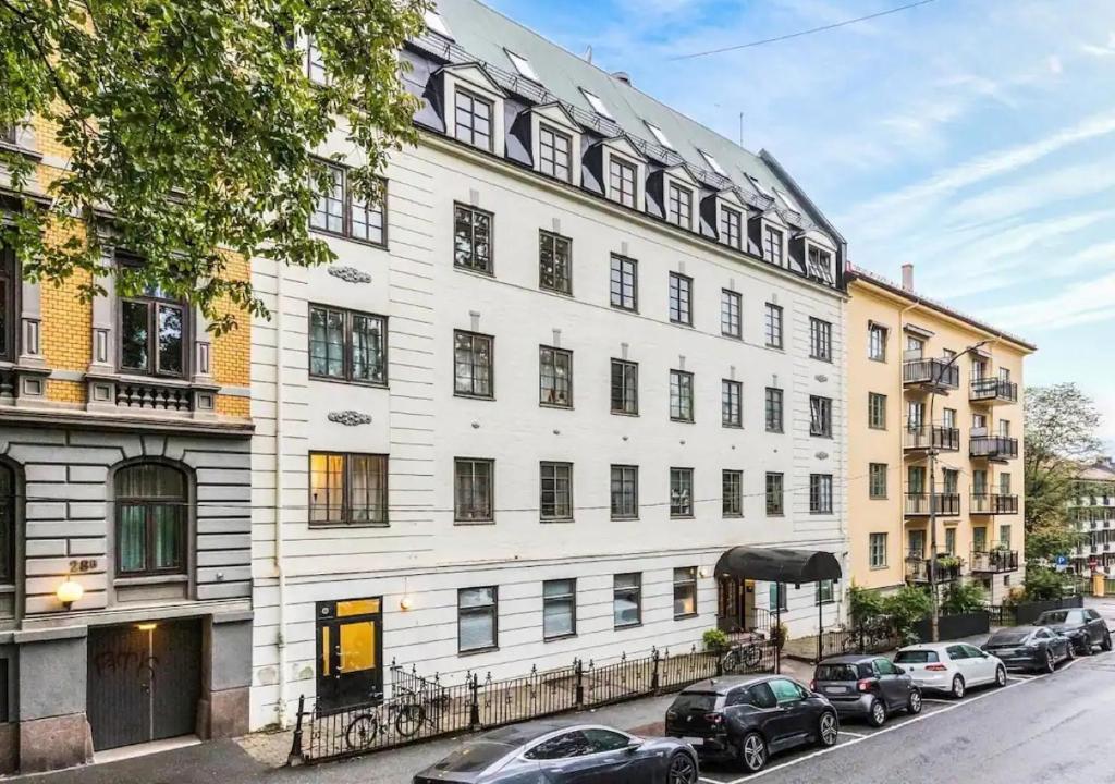 a white building with cars parked in front of it at Newly renovated studio apartment at Frogner in Oslo