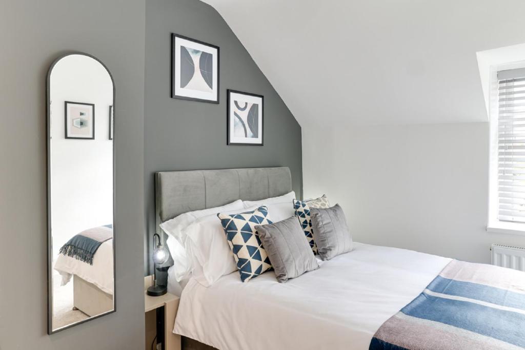 a bedroom with a bed and a mirror at Beam End Snainton - Modern 2-bedroom Stone Cottage in Snainton