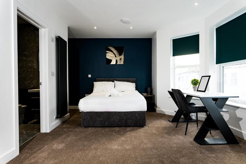um quarto com uma cama e uma secretária com uma mesa em The Get Away em Great Yarmouth