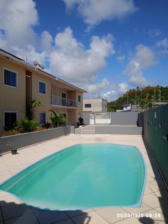 een groot blauw zwembad voor een huis bij Condominio Vento Leste in Porto Seguro