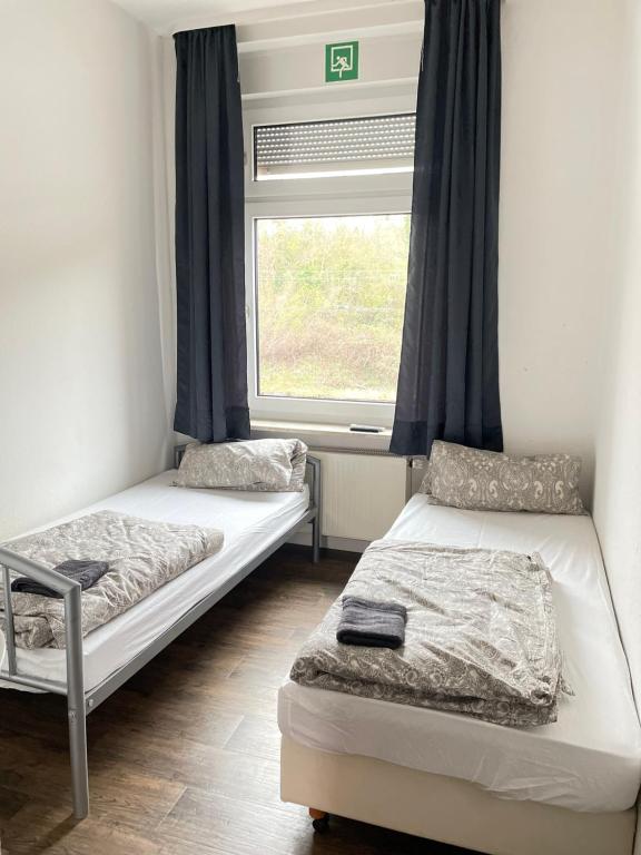 two beds in a room with a window at Pension Nierstein bei Mainz in Nierstein