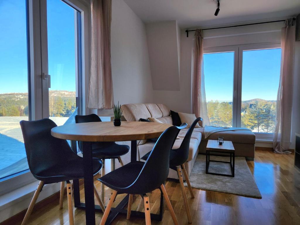 sala de estar con mesa, sillas y sofá en PoinT, en Divčibare