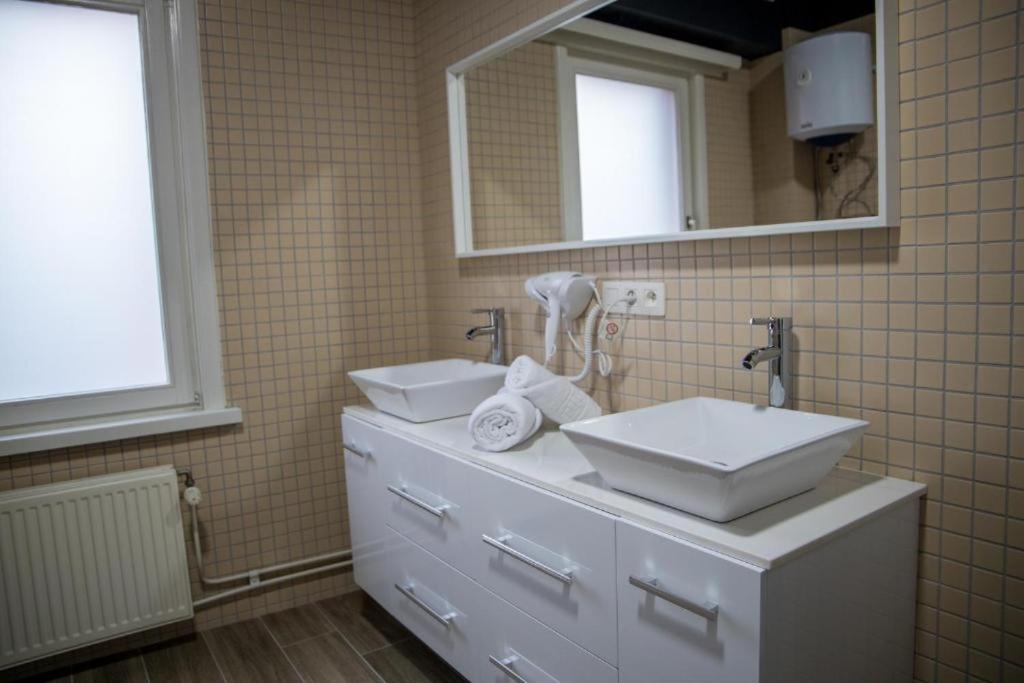 a bathroom with two sinks and a mirror at Hotel Guzy in Lier