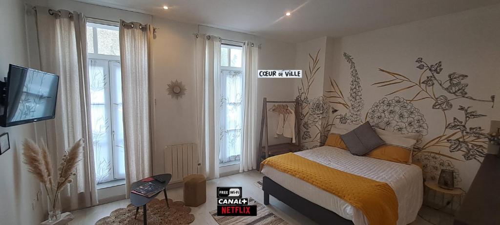 Un dormitorio con una cama y un televisor y ventanas. en Les arcades Studio Coeur de ville, en Cholet