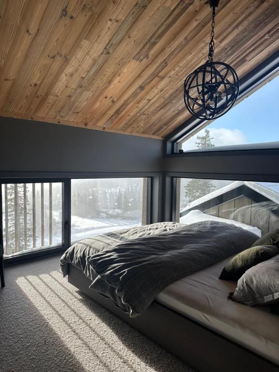 1 dormitorio con 1 cama con techo de madera en Norefjell Chalet, en Surteberg