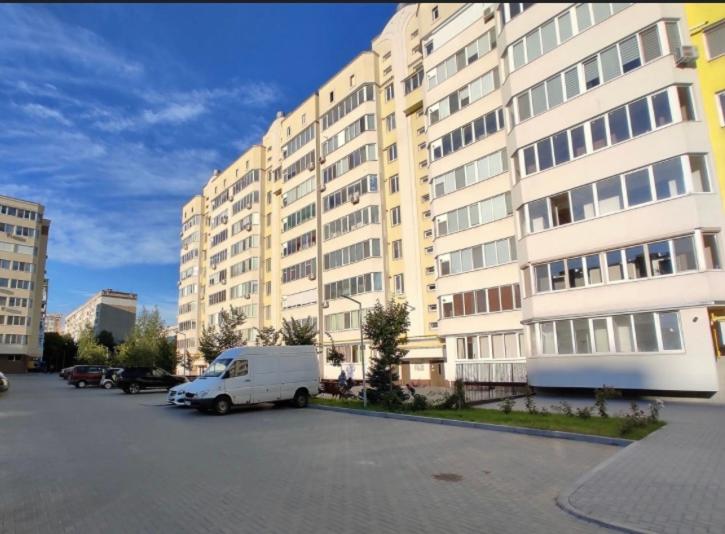 a white van parked in a parking lot in front of a building at Ciocana apartament in Chişinău