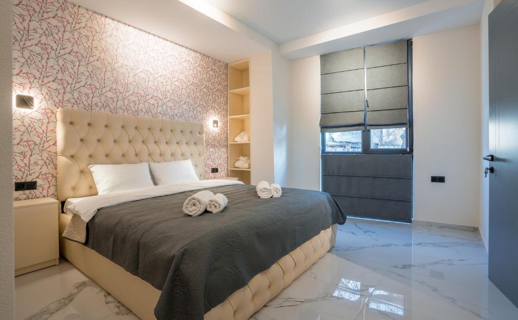 a bedroom with a large bed with two towels on it at Luxury X By umbrella in Tbilisi City