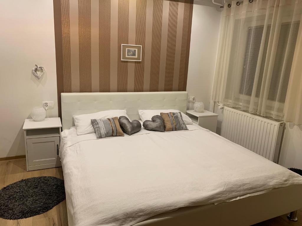 a bedroom with a large white bed with two pillows at Apartma Eli in Bled
