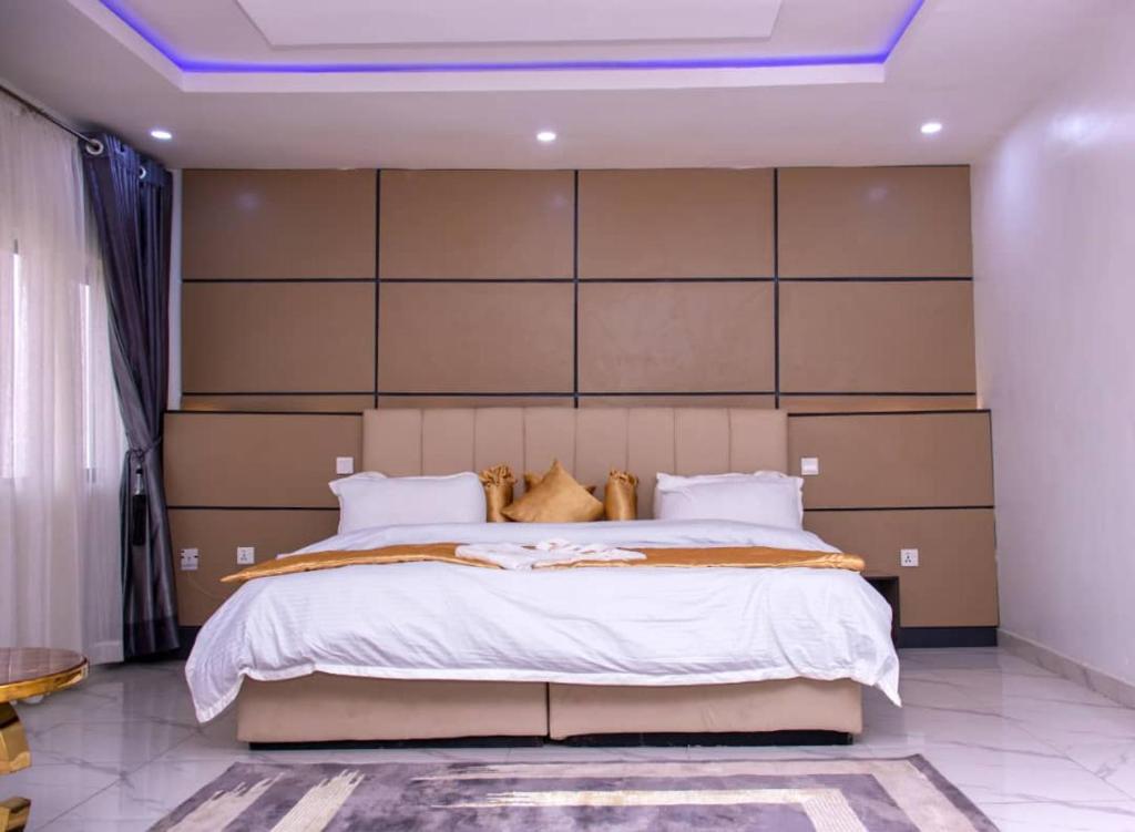 a bedroom with a large bed with a large headboard at HASB APARTMENTS in Lagos
