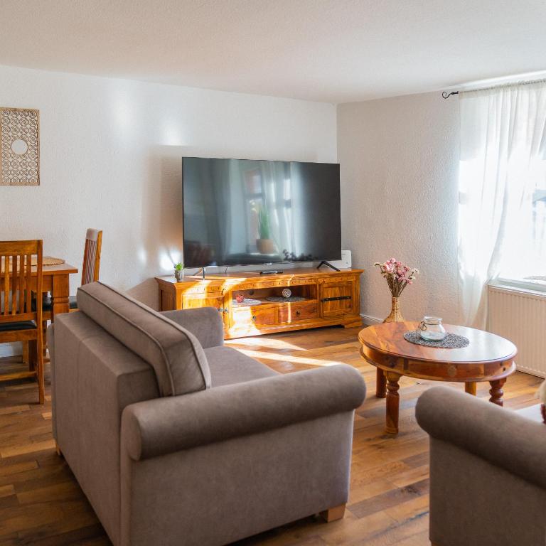 a living room with a couch and a tv at Sabina Ferienhaus in Trebbin
