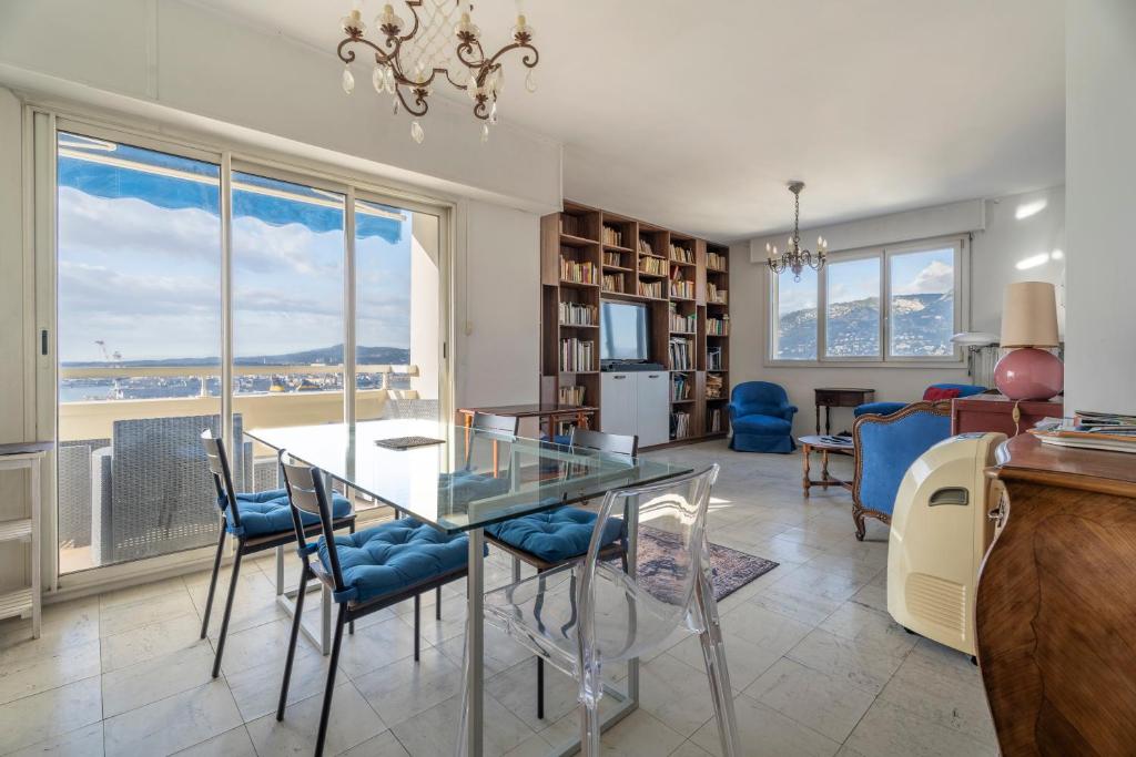 une salle à manger avec une table et des chaises en verre dans l'établissement Vue panoramique, grand appartement 2 chambres à Toulon, à Toulon