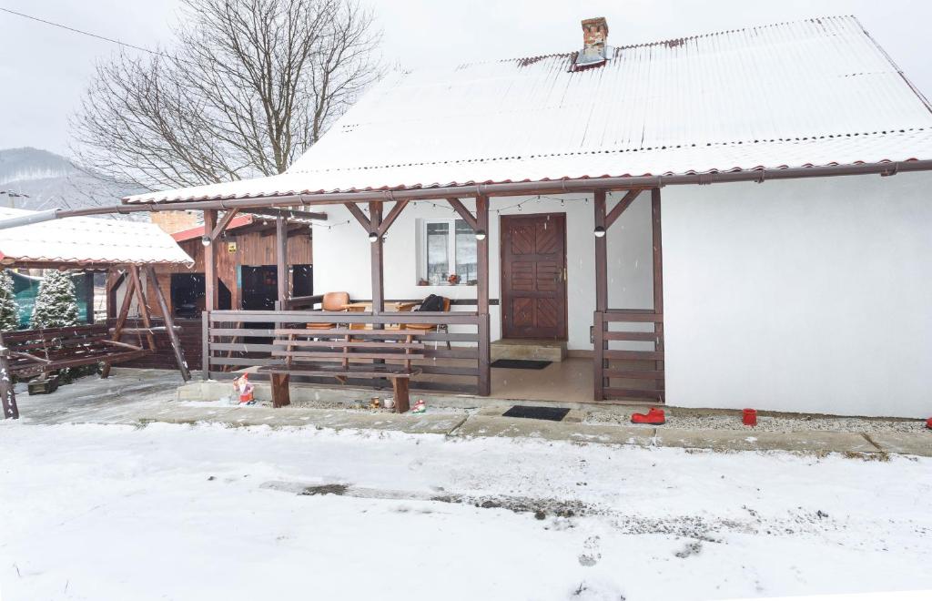 a house with a snow covered roof and a porch at Casa De Vacanta Armi in Molidu