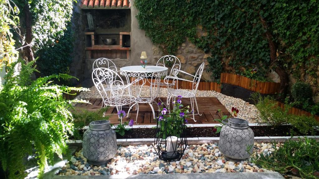 un patio con mesa y sillas en un jardín en La Casa de Su, en Baños de Montemayor